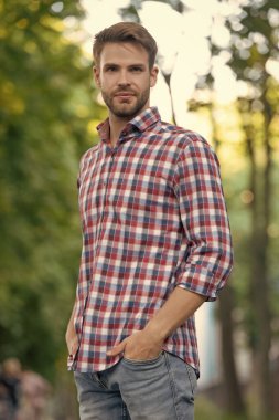 Dışarıdaki kareli gömlekli kendine güvenen genç adam..