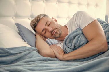 Olgun adam yatakta uyuyor. Sabah erken saatlerde.