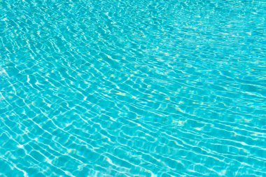 Turkuaz yaz havuzu arka planının fotoğrafı. Yaz havuzu su arka planı. Yaz havuzu arka planında dalgalar var. Yaz havuzu geçmişinde kimse yok..