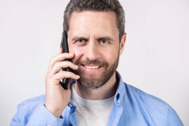 Stüdyoda iletişim kuran bir adamın portresi. İnsanoğlunun iletişim çağrısı. İletişim kuran bir adamın fotoğrafı. Adamın telefon görüşmesi var. Stüdyoda izole edilmiş..