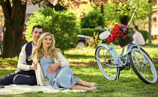 Never boring. picnic of couple in love at vintage bike. family relationship and friendship. summer holiday trip. girl and man under sakura. couple in love drinking wine during romantic dinner in park.
