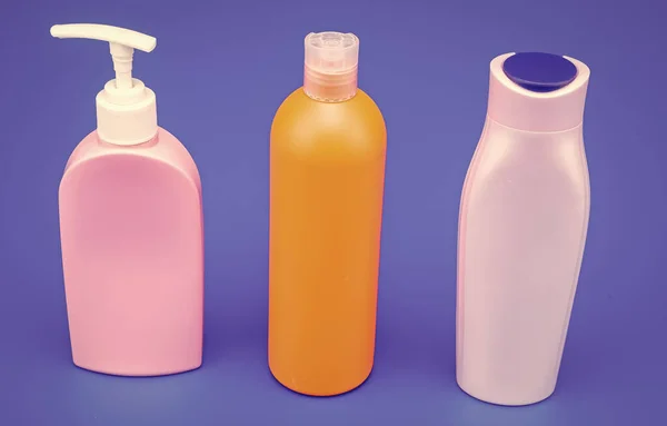 Refillable plastic liquid cosmetic packaging containers HDPE multicolor blue background copy space, bottles.
