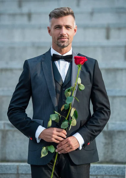 特殊场合的概念 优雅的男人 带着玫瑰参加特别的场合 特定场合的室外燕尾服男 — 图库照片