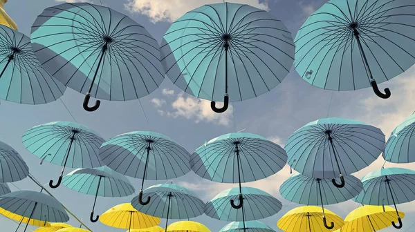 stock image Umbrella sky background. Blue and yellow umbrellas hanging bottom- up. Street decoration.