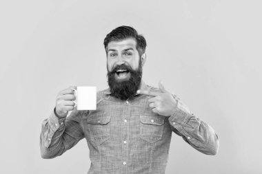 Kahve fincanını gösteren mutlu adam sarı arka plan, kopyalama alanı.