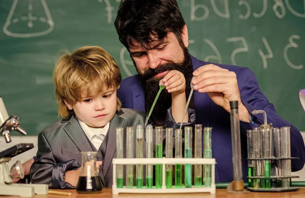 laboratory research and development. bearded man teacher with little boy. Laboratory test tubes and flasks with liquids father and son child at school. Chemistry beaker experiment. study of matter
