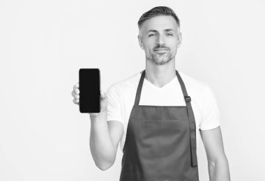 Önlüklü gülümseyen olgun bir adam akıllı telefona fotokopi alanı sunuyor..