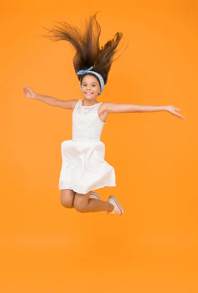 Jumping in mid air. Light and easy. Freedom. Kid full of energy jumping enjoy long healthy hair. Cute hairstyle. Happy childhood. Carefree baby. Beautiful hairstyle. Daily hairstyle for girls.