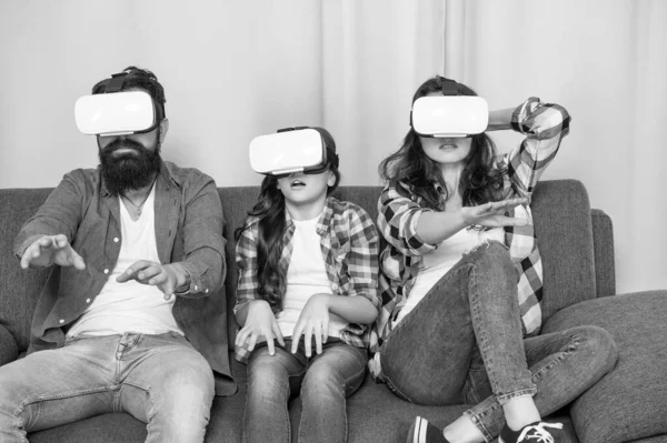 mom dad and daughter. digital future and innovation. modern life. father mother and child wireless VR glasses. virtual reality family. parents with kid girl use modern technology.