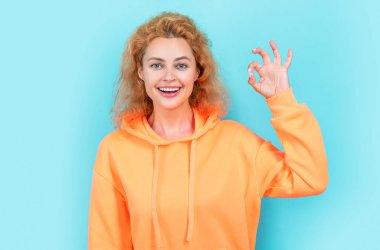 stylish woman at studio, ok. photo of stylish woman in hoodie. redhead stylish woman on color background. stylish woman isolated on blue background.