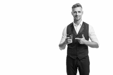Takım elbiseli mutlu adam tek kullanımlık fincanı işaret ediyor ve beyaz çay ısmarlıyor..