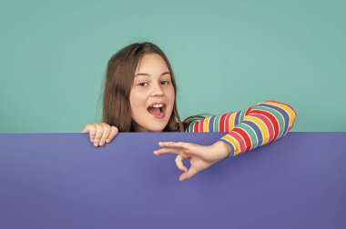 Reklam için fotokopi alanı olan boş mavi kağıdın arkasında büyülenmiş bir çocuk. Tamam.