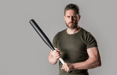 angry man threatening, copy space. angry man express anger with bat isolated on grey background. aggression of angry man with bat in studio. photo of angry man hold bat.