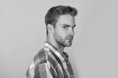 Yakışıklı, tıraşsız, ciddi yüzlü yarım sarı arka plan, portre.