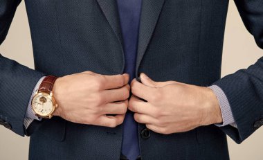 Lüks kol saati olan resmi takım elbiseli bir adam..