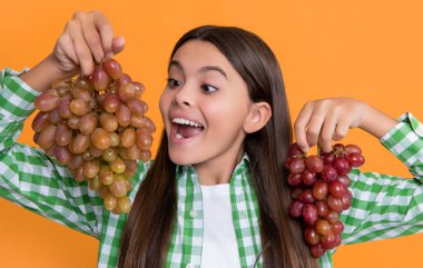 Sarı arka planda üzümlü genç bir kız..