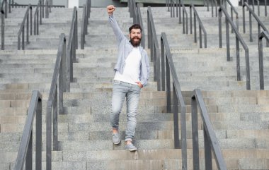 Mutlu sakallı adam aşağıya iniyor. Uzun boylu, sakallı bir adam. Merdivenlerdeki hippi çocuk..