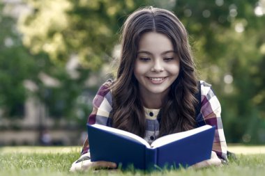 Okumak sadece bilginizi arttırır. Mutlu çocuk yeşil çimlerin üzerinde yatan kitabı okudu. Okul kütüphanesi. Hayal gücü ve fantezi. Edebiyat eğitimi. Okumak iyi bir hobidir..
