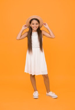 Sıcak bir gülümseme. tatil havası. Küçük kız tatilde. Hasır şapkalı çiftlik çocuğu. Sarı arka plandaki küçük sevimli şey. Pozitif kızın mutlu çocukluğu. Güzellik. Çocuk yaz modası. Plaj partisine hazırım..