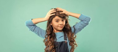 Kıvırcık saçlı neşeli çocuk. Gençlerin saç stili. Kadın manken. Kıvırcık saçlı kıvırcık. Kızın dalgalı bir saçı var. Tüylü çocuk portresi. Komik duygularını ifade et. Saç bakımı ve cilt bakımı. Kuaför..