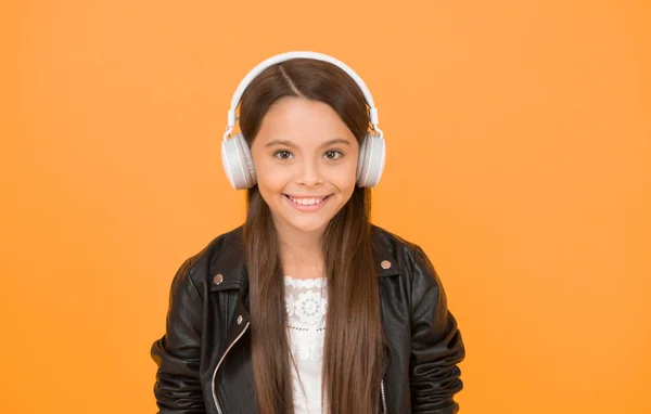 Enjoying every note. Musical education. Music creation and distribution. Musical taste. Musical accessory. Gadget shop. Small girl listening music wireless headphones. In love with stereo sound.