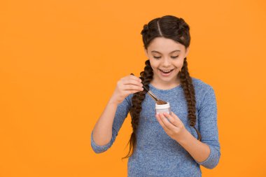 Saçları örgülü mutlu genç kız sarı arka planda toz ve fırça kullan, kozmetik.
