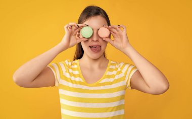 Sarı arka planda dudaklarını yalayan makaronlu genç kız..