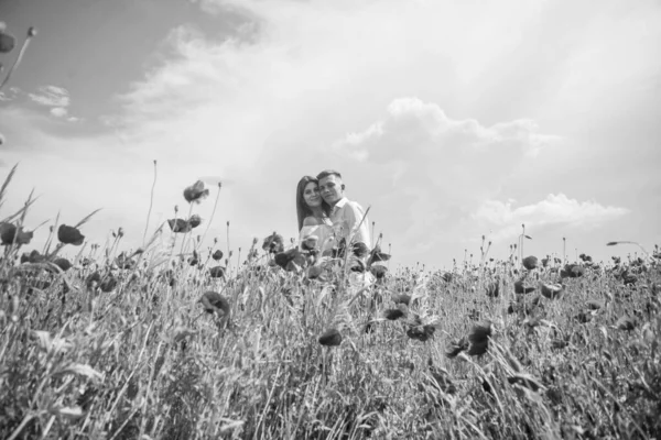togetherness. man and woman in poppy field. summer flower meadow. romantic couple among poppies. love and romance. opium. bride and groom on spring wedding. lovers in flower field. couple in love.