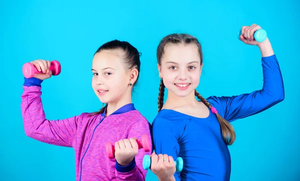 Happy strong children with barbell. workout of strong small girls hold dumbbell. weight lifting for muscules. Fitness diet for energy health. Sport success. proud to be strong. strong family bonds.