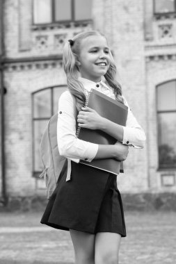 Okul üniformalı mutlu çocuk kitap ve sırt çantası taşıyor, eğitim görüyor..