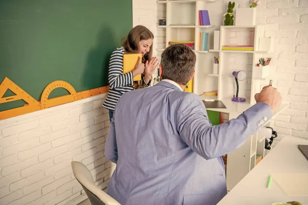 angry teacher shouting at child at blackboard. violence.