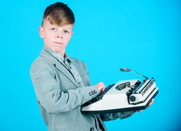 I will be a news reporter. A cute child reporter on blue background. Small reporter holding retro typewriter. Little reporter typewriting message or article on mechanical desktop typewriter.