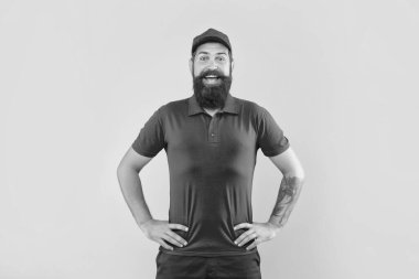 Kırmızı şapkalı ve tişörtlü mutlu sakallı adam kolları dövmeli sarı arka planlı, adam.