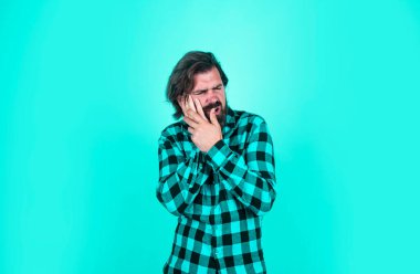 Mutsuz yakışıklı hipster 'ın dişi ağrıyor. Olgun adamın bıyığı var. Acıyı hisset. Kareli gömlekli sakallı adam. Duygusal yüzlü vahşi bir adam..