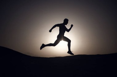 adam siluet, dağ, spor ve Rekreasyon, gelecek ve başarı, insan ve doğa, hız ve sağlıklı yaşam, günbatımı ateşli gökyüzü arka plan üzerinde çalışan adam alanı Kopyala