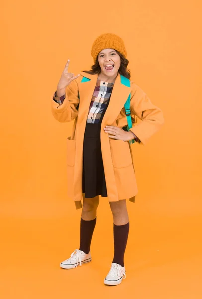 In rock style. Small girl gesture horn sign in formal style. Little cute child wear autumn fashion style. School dress code. School uniform never goes out of style.