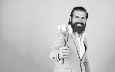 Bu da senin için. Hipster adam lale çiçeği tutar. Romantik randevu için hediye. Zarif ceketli sakallı adam çiçekleri tutuyor. Düğün günü. Babalar günün kutlu olsun. Olgun gelin buketli damat.