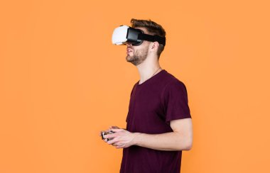 Başka bir gerçeklik burada. VR kulaklıklı bir erkek. Oyuncu modern teknolojiyi kullanır. Dijital gelecek ve yenilik. Görsel gerçeklik. Kablosuz VR gözlüklü adam. Adam video oyunu oynuyor. konsollu oyun oynatıcı.