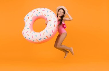 Neşeli çocuk rahatlıyor. Bilardoda dinleniyorum. Yaz tatili. Eğlence konsepti. Yüzme havuzlu otel. Küçük kız ve yüzme yüzüğü. Mayolu çocuk rahatlıyor ve eğleniyor. Yaz tatili.