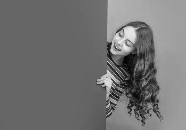 Boş mavi kağıdın arkasında reklam için fotokopi alanı olan mutlu meraklı çocuk.