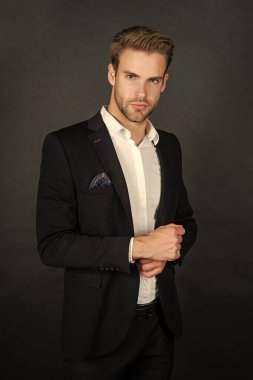 Siyah arka planda takım elbiseli genç adam, moda..