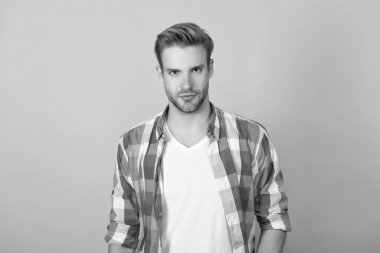 Gerçekten yakışıklı. Normal erkek portresi. Yakışıklı, sarı arka plan. İşaretli gömlekli genç adam. Ciddi bir erkek..