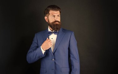 Mavi smokinli ciddi bir adam. Önüne bak. Siyah arka planda resmi giyinen garson. Erkek resmi moda. Boşluğu kopyala.