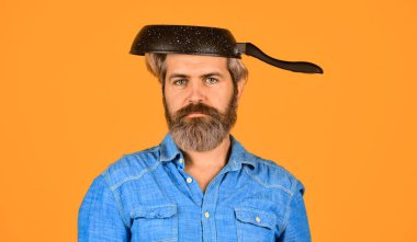 Tereyağından kıl çeker gibi. Adam tavayı tutar. Kızartma yemeği. Sağlıklı yiyecekler. Sakallı hippi kahvaltı hazırlıyor. Krep için mükemmel. Yağsız kızartılıyor. Profesyonel mutfak gereçleri. Kızartma için yapışmaz tava.