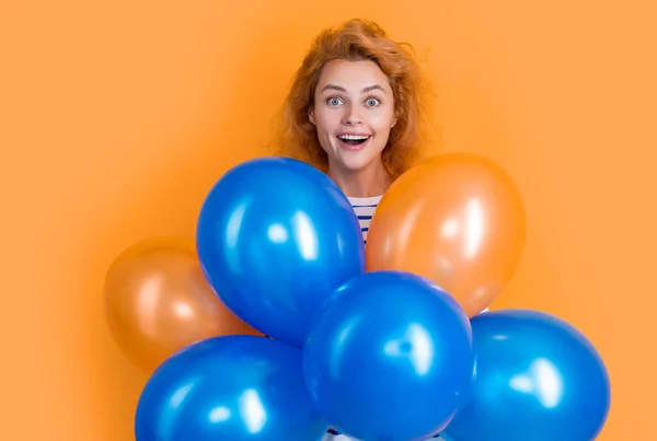 surprised girl hold party balloons in studio. girl with balloon for party isolated on yellow background. party girl with balloon.