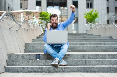 communication of successful freelancer man outside. freelancer man has communication at coffee break. freelancer man has communication on laptop. freelancer man has communication on pc outdoor.