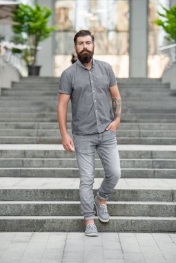 Sakallı adam aşağı iniyor. Uzun boylu, sakallı bir adam. Hipster adam dışarıda..