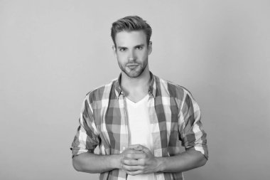 Ciddi ol. Ciddi bir erkek portresi sarı arka plan. Damalı gömlekli yakışıklı adam. Çocuk el ele tutuşuyor. Düz dur..