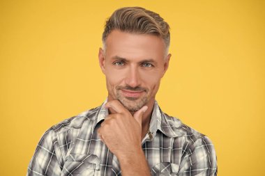 Beyaz saçlı neşeli olgun bir adam ve sarı arka planda pürüzsüz bir ten..