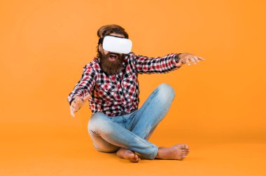 VR kulaklık kullanan bir adam. Sakallı hippi modern teknoloji kullanır. Sanal gerçeklik gözlüklü bir adam. Dijital gelecek ve yenilik. Dijitalleştirme. Bir programlama projesi üzerinde çalışıyorum.